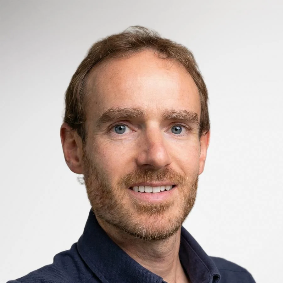 A man with short brown hair, blue eyes, and a beard, smiling as if for ID photos. A man with short brown hair, blue eyes, and a beard, smiling as if for ID photos.