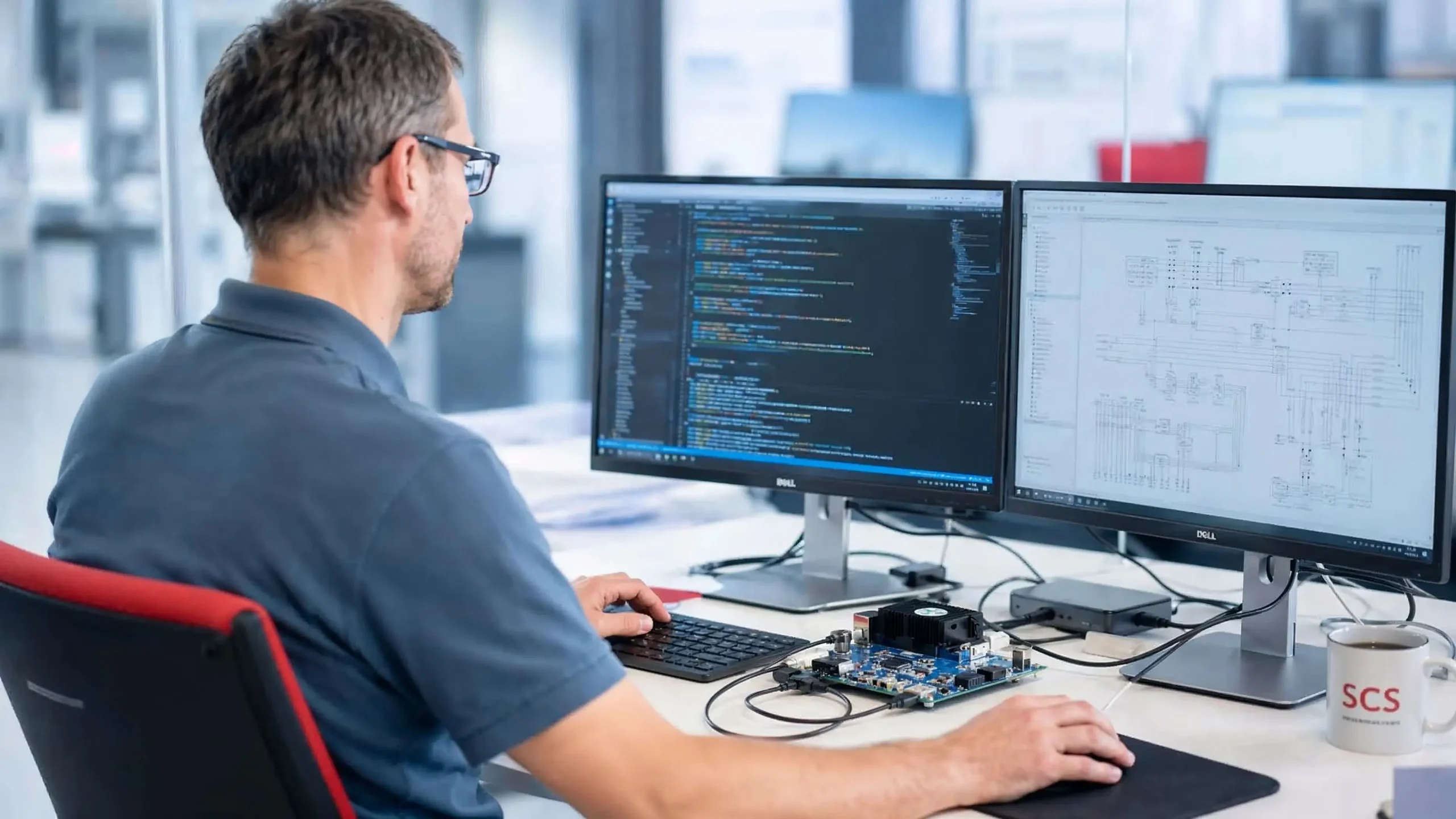 Mann am Schreibtisch mit zwei Bildschirmen, auf denen Code und Schaltpläne für den IT-Dienstleister Schweiz angezeigt werden. Mann am Schreibtisch mit zwei Bildschirmen, auf denen Code und Schaltpläne für den IT-Dienstleister Schweiz angezeigt werden.
