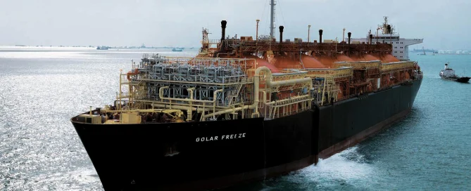 The large LNG tanker "Golar Freeze" with industrial automation sails calmly, a tugboat is nearby.