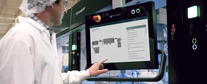 A person in a lab coat monitoring schematics of industrial systems via a touchscreen.