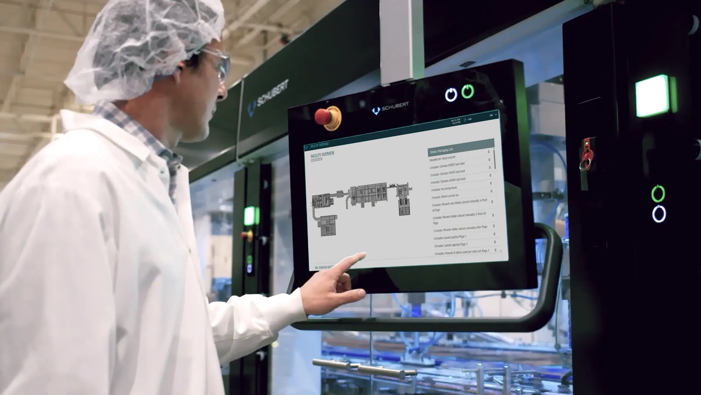 A person in a lab coat monitoring schematics of industrial systems via a touchscreen.