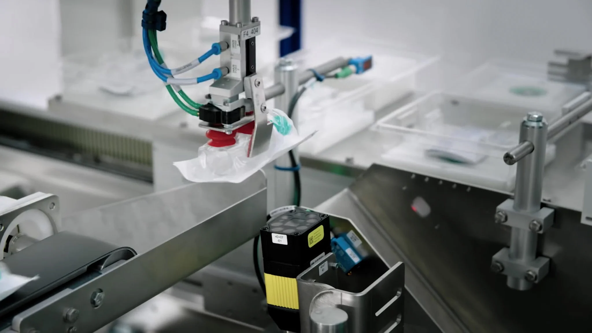 Ein Roboterarm verschließt eine Plastiktüte in einer modernen Verpackungsmaschine mit modernster Automatisierungstechnik. Ein Roboterarm verschließt eine Plastiktüte in einer modernen Verpackungsmaschine mit modernster Automatisierungstechnik.