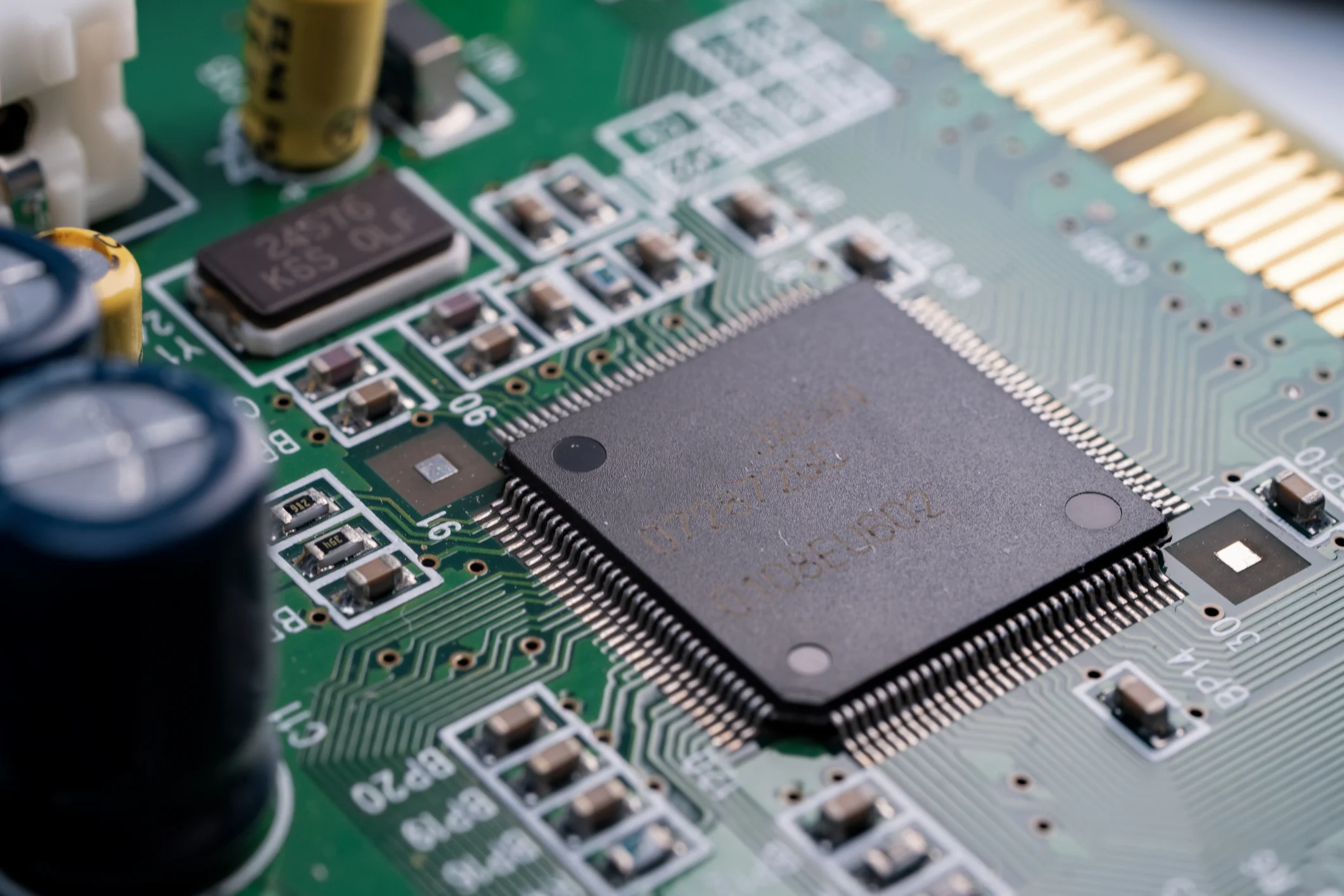 Nahaufnahme eines Mikrochips auf einer grünen Leiterplatte, die in FPGA-Entwicklungsprojekten zum Einsatz kommt. Nahaufnahme eines Mikrochips auf einer grünen Leiterplatte, die in FPGA-Entwicklungsprojekten zum Einsatz kommt.